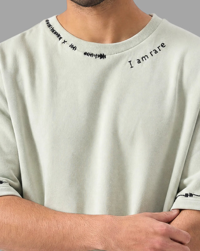 Light gray t-shirt with text 'I am rare' on a person wearing it.