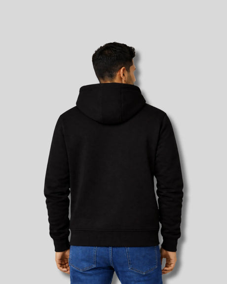 Person wearing a black hoodie from behind on a light gray background